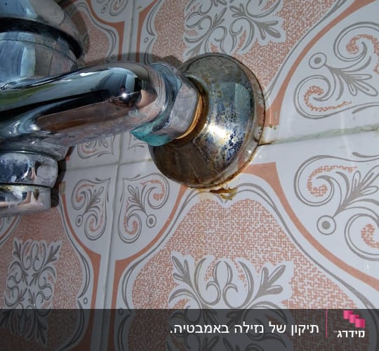 ברז מתכת עם חלודה על אריחי קרמיקה